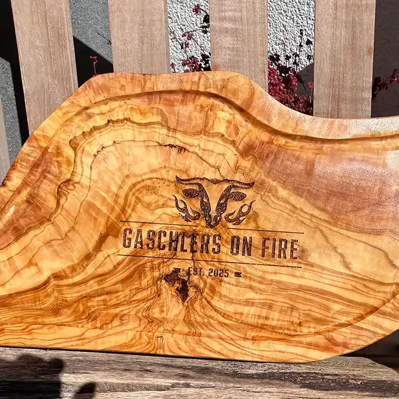 Motiv "On Fire" mit stilisiertem Rinderkopf mit Flammen und Personaliserungsoption mit Name in Großbuchstaben und Datum - Mediterranes Schneidebrett aus Olivenholz mit Saftrille mit und ohne Grifflasche oder Handgriff - Personalisiertes Männergeschenk von Jeske Design