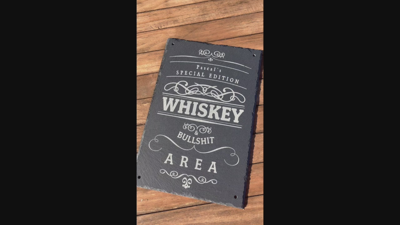 Dekoratives Schild aus Schiefer mit dem Text "Special Edition Whiskey Bullshit Area", welches personalisiert werden kann in der Größe 20 x 30 cm oder 30 x 30 cm im Hochformat. Hier mit 4 Loch in den Ecken für die Befestigung als Beispiel